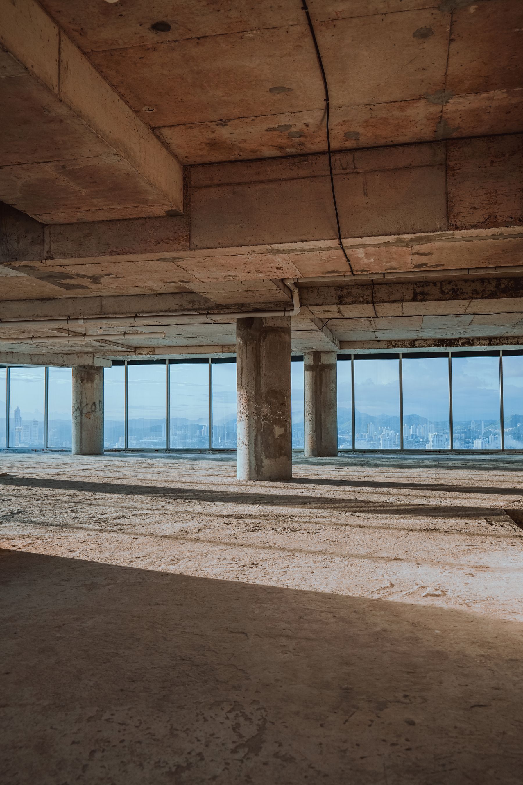 Terrace as a bare shell: an open concrete deck with bare columns and an unglazed edge.